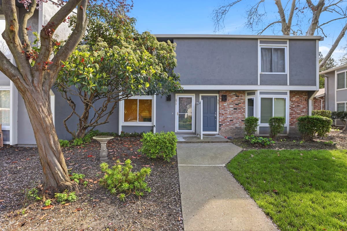 A two-story Bay Area home with mature shrubs out front, professionally managed by Bay Vista PM.